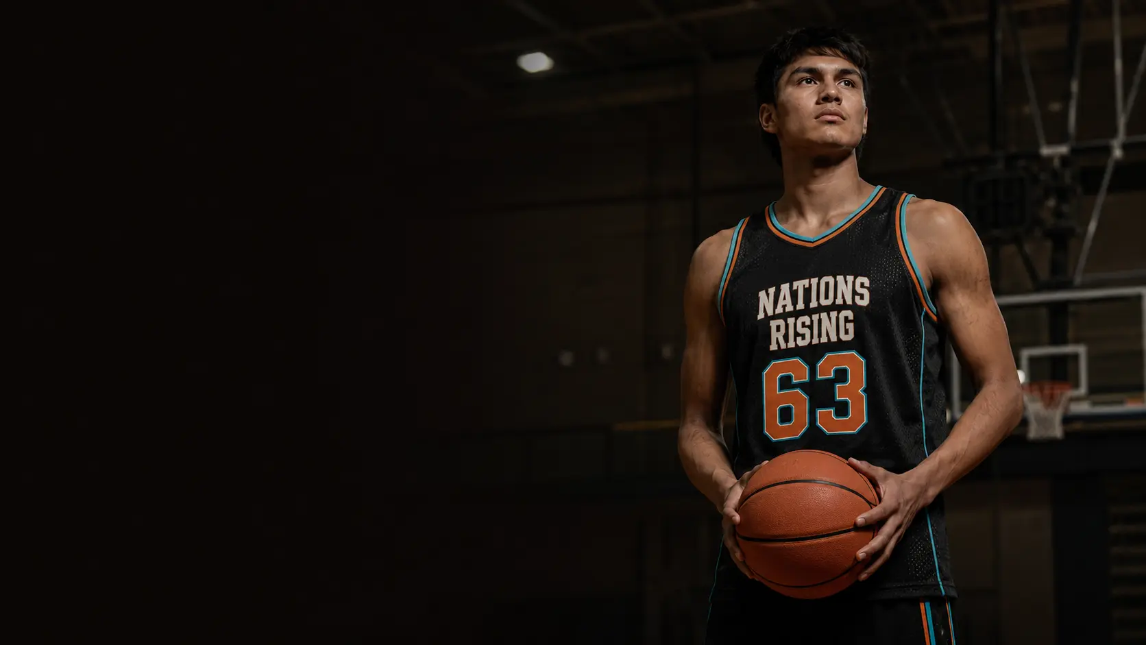 A Nations Rising basketball athlete holding a ball in an indoor gym